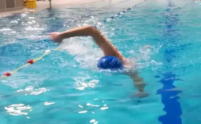 Nageur en crawl dans un bassin couvert lors d'un entraînement du club